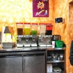 A row of drink dispensers with different colored liquids inside.