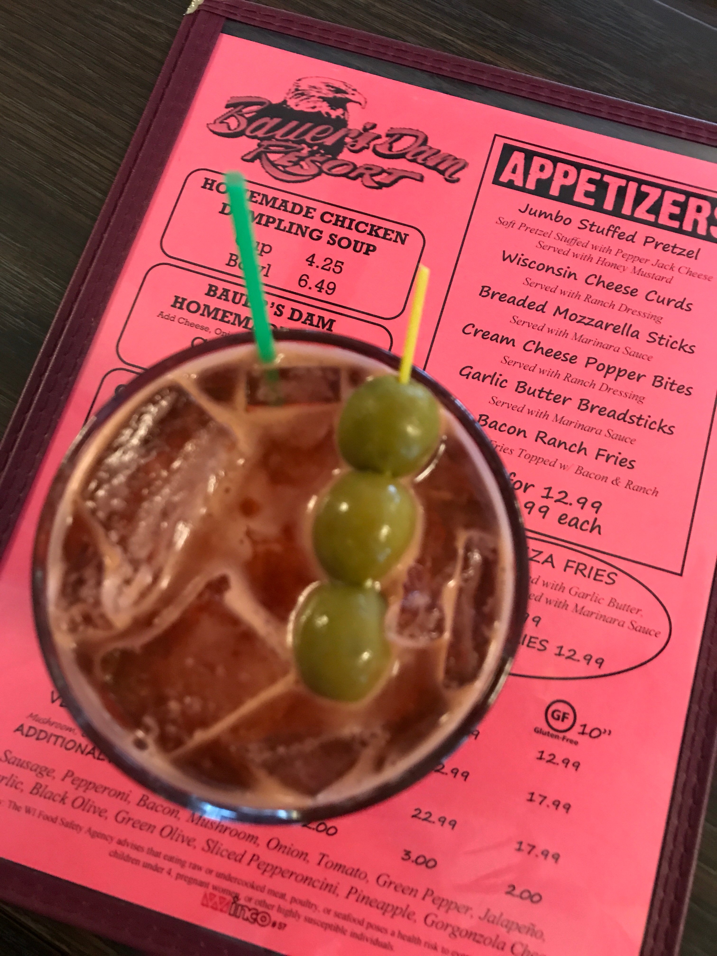 A Bloody Mary seen from above on a pink bar menu.