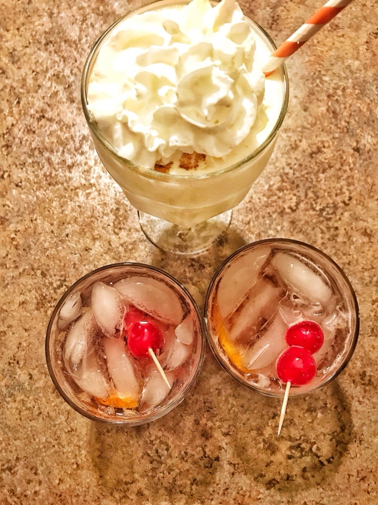 An overhead view of a rumchata milkshake and two brandy old fashioneds. 