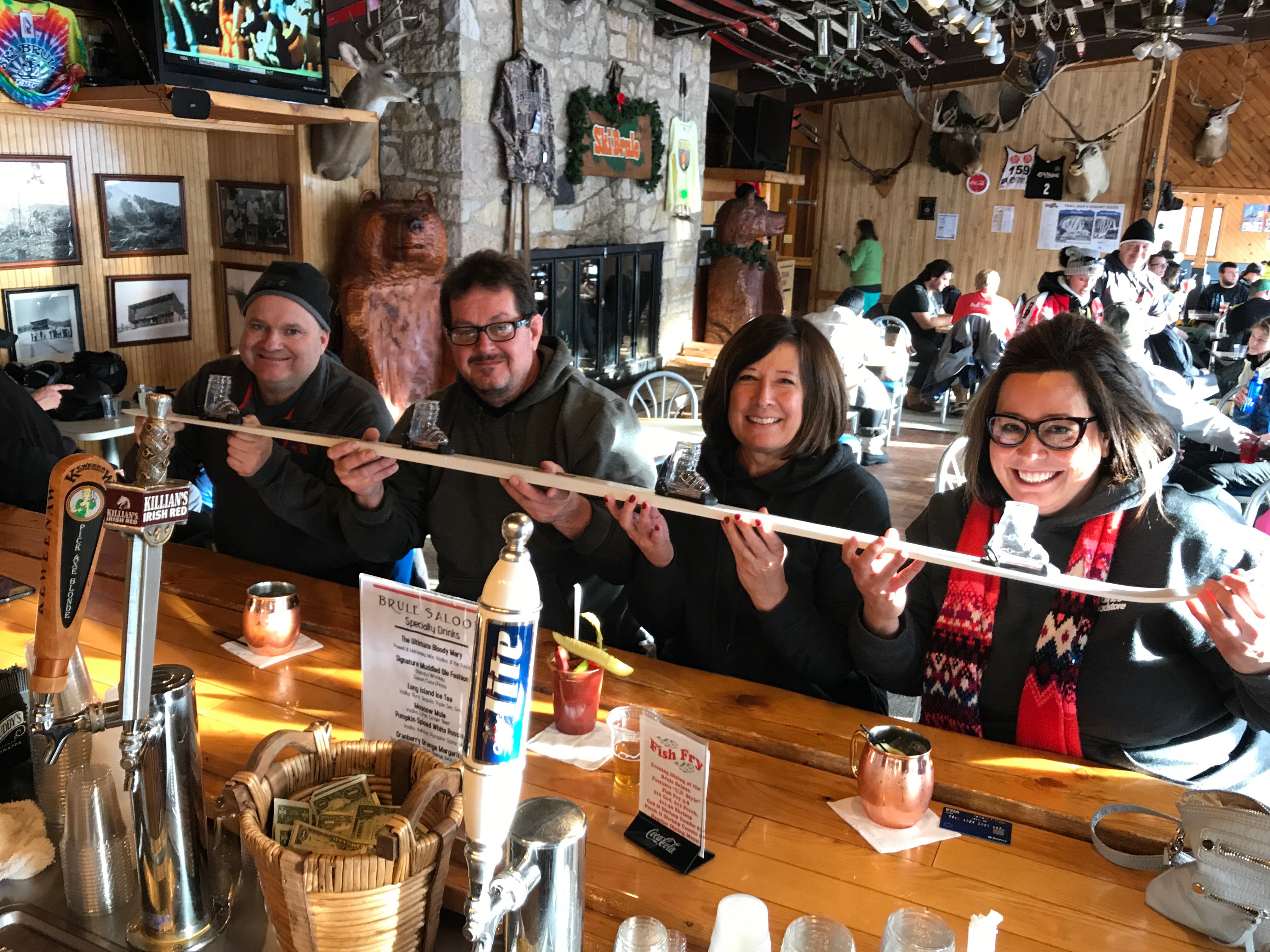 Me and my mom and two others sharing 4 shots shaped like ski boots on a big ski.