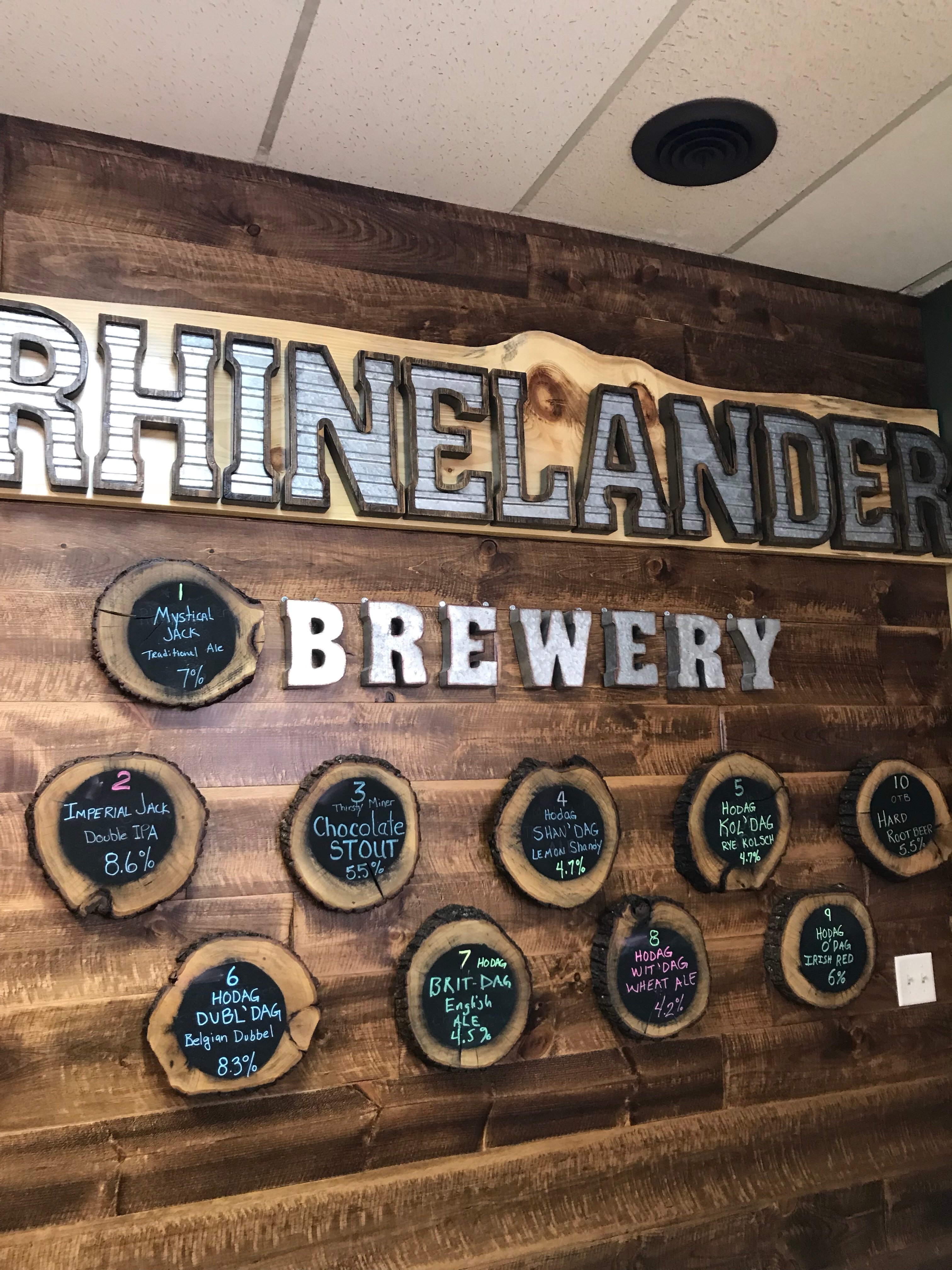 The wall of the Rhinelander Brewery. The different types of beers on offer are listed on the wall. It is all made of wood or looks like it is, at least.