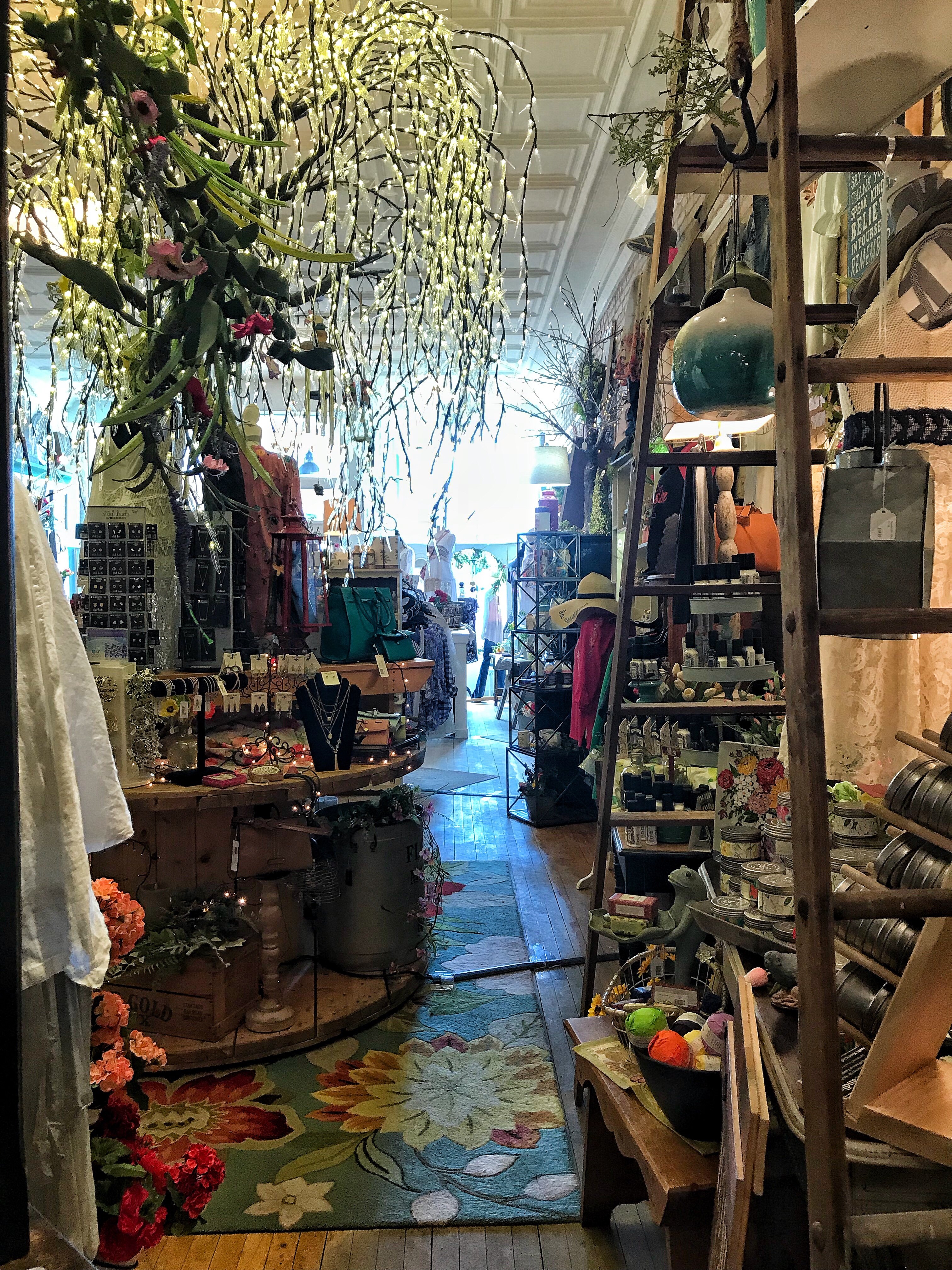 The interior of Tricia's Treasures, a shop with various curios and an indoor tree with lights on it.