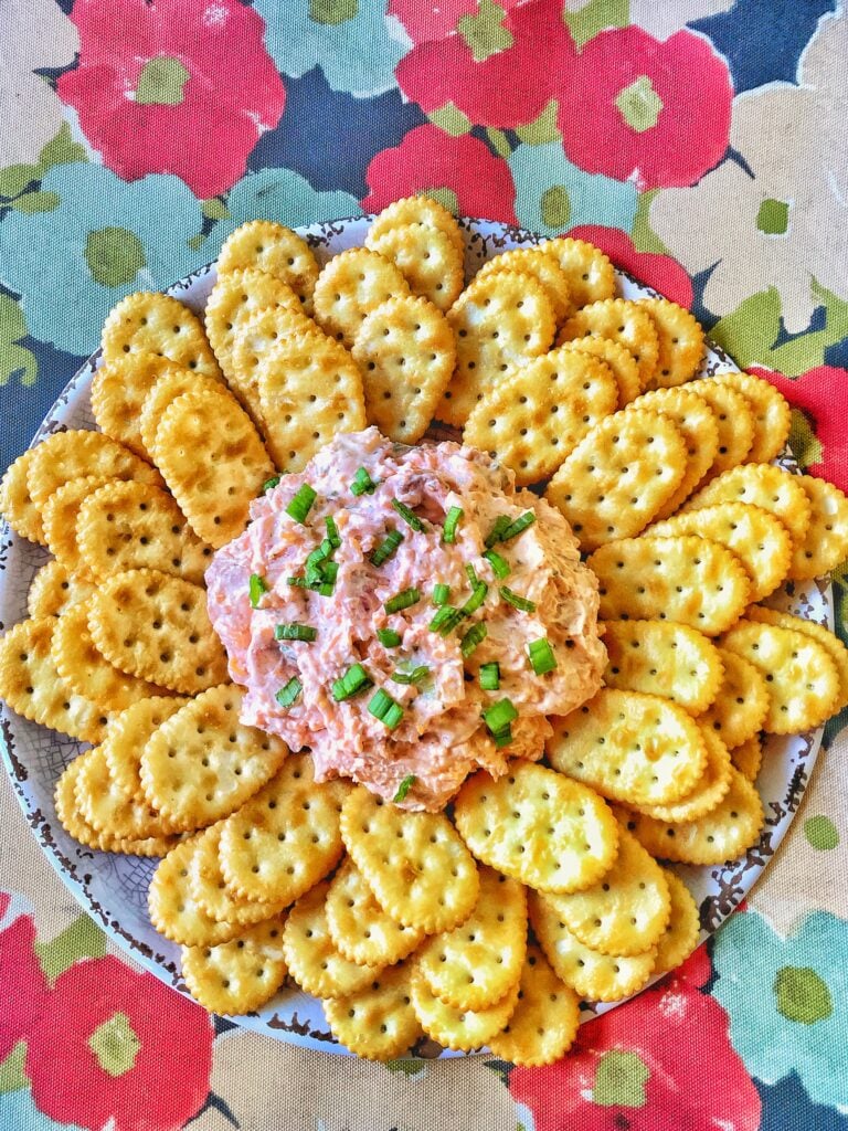 Oval crackers laid out around a cheesy supper club spread.
