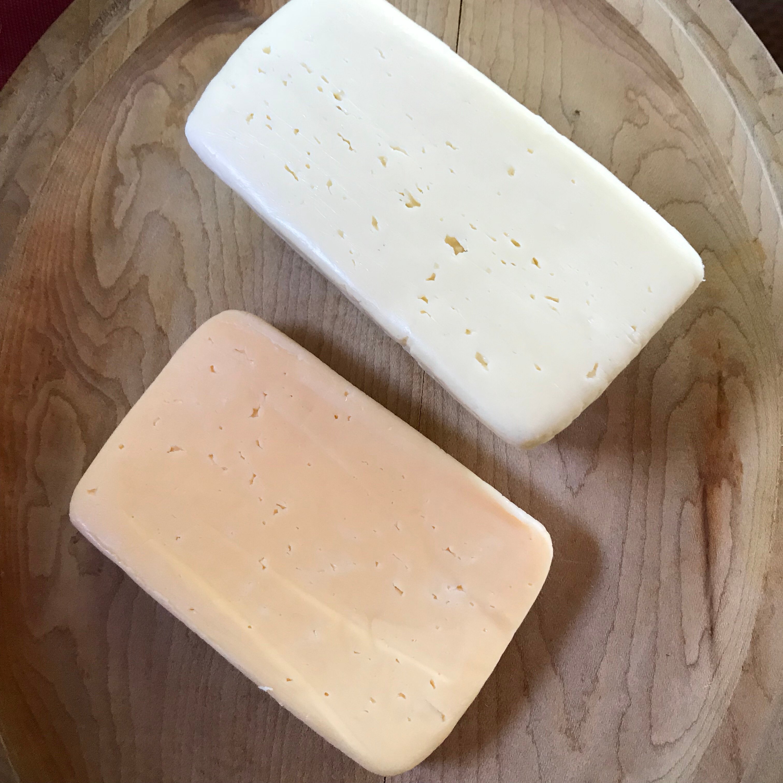 An orange brick cheese and a white brick cheese.