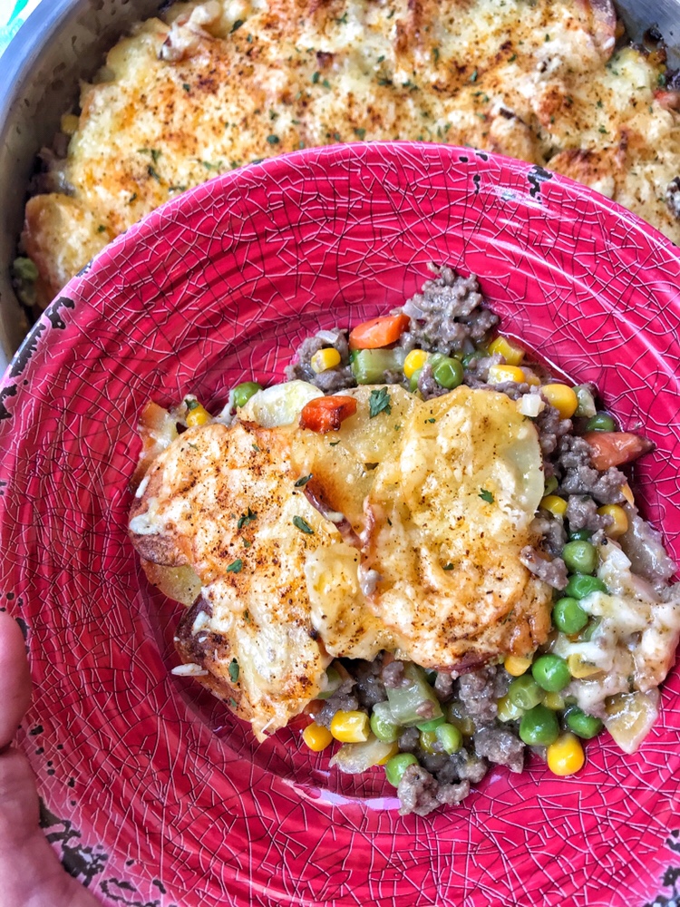 Creamy Scalloped Potatoes and Savory Beef in a red bowl.
