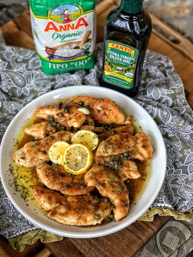 A plate of fried chicken cutlets with capers, butter, olive oil and anchovies.