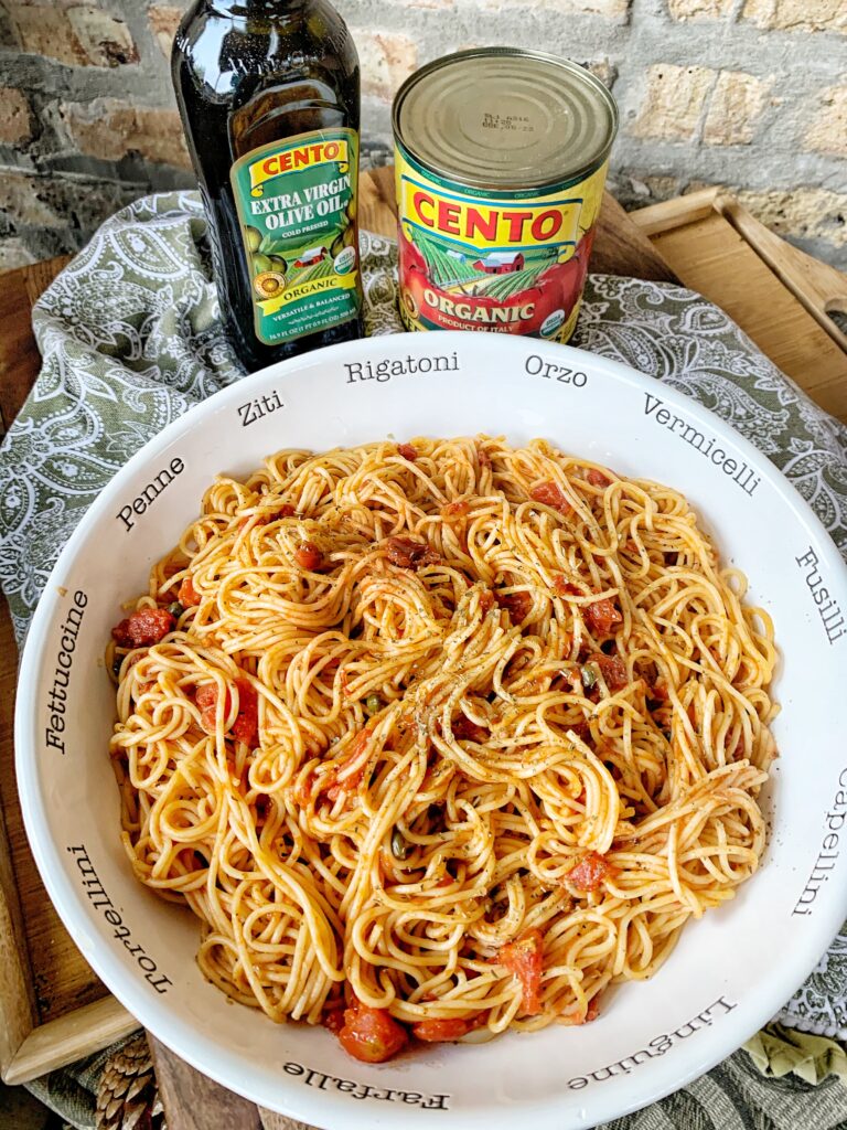 Tomato pasta with thin spaghetti in a white bowl goes great with the lemon caper chicken cutlets
