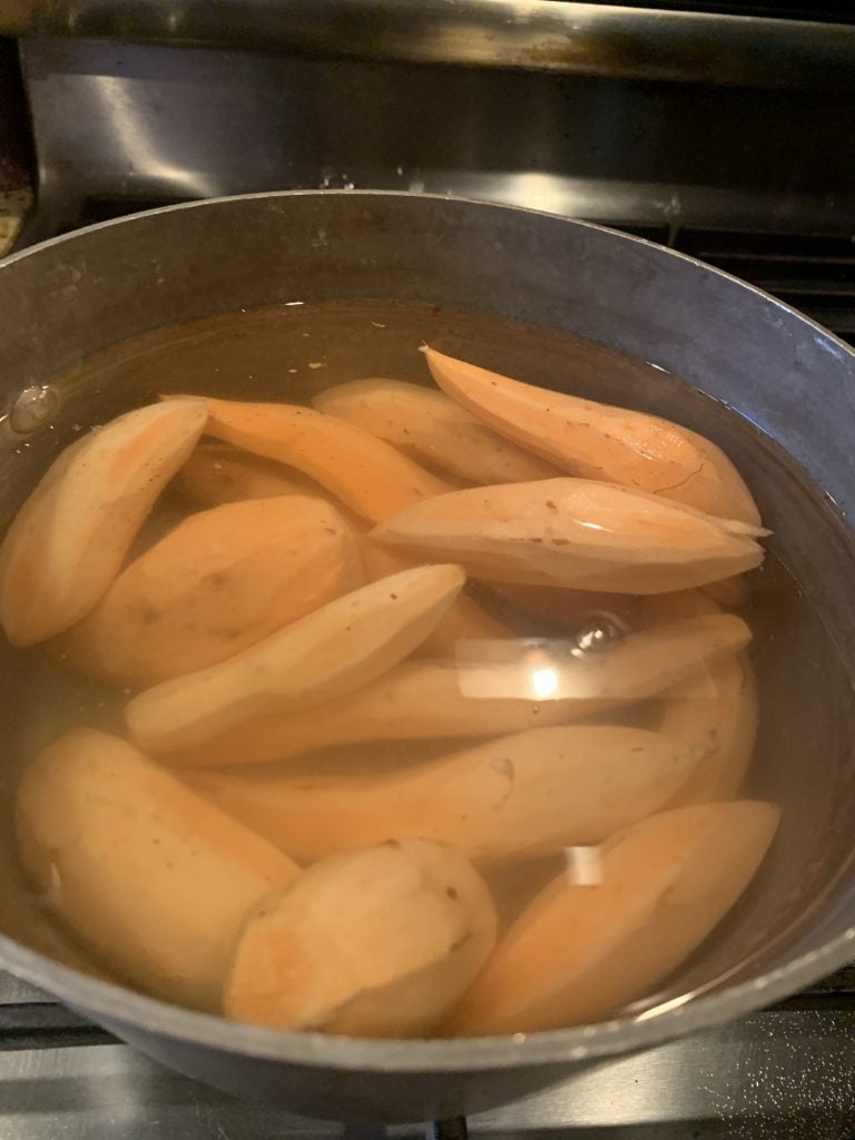 Sweet potatoes boiling in a pot.