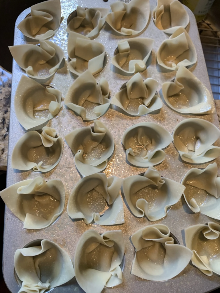 Wonton wrappers pressed into a mini muffin pan