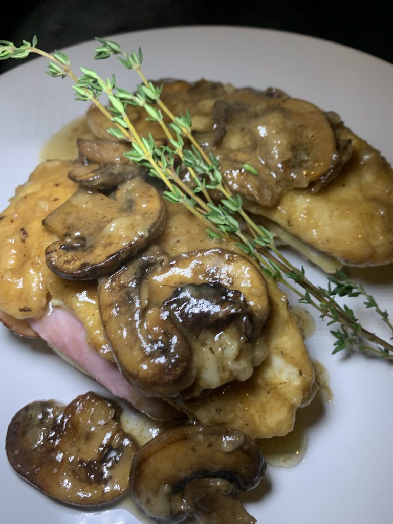 Chicken covered in ham, mushroom sauce, and thyme