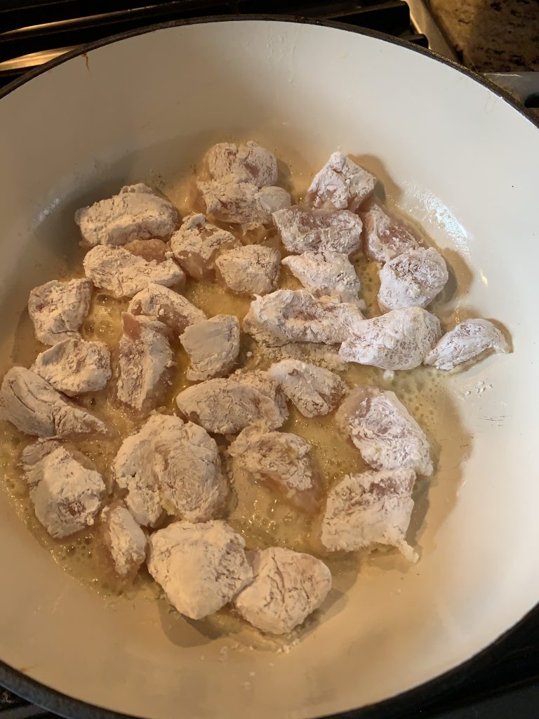 Pieces of chicken cooking in a skillet