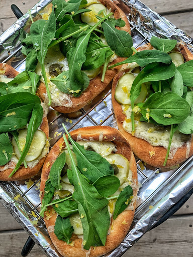 The finished Dill Pickle Flat Breads topped with lemon zest, arugala, and capers