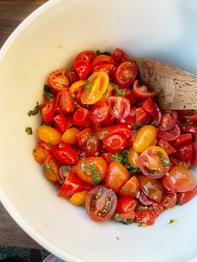 Diced tomatoes with kosher salt and garlic in a bowl.