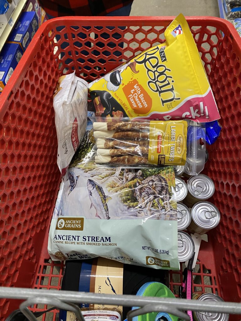 A shopping cart filled with various supplies for dogs and birds