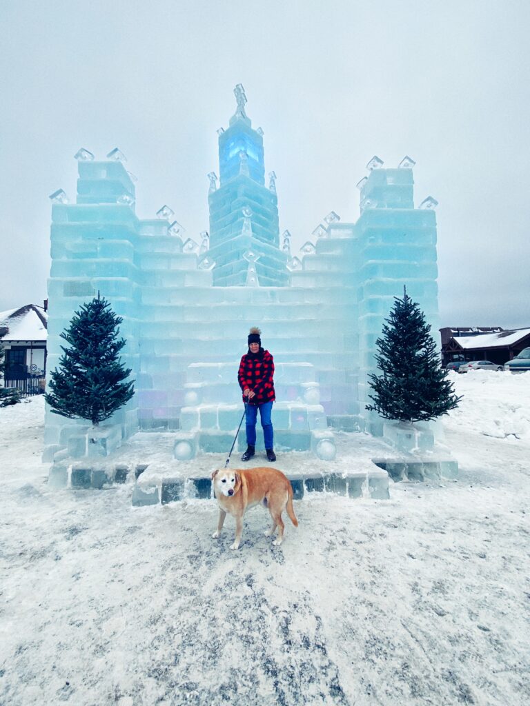 My mom with our dog, Bailey, in front of an ice castle