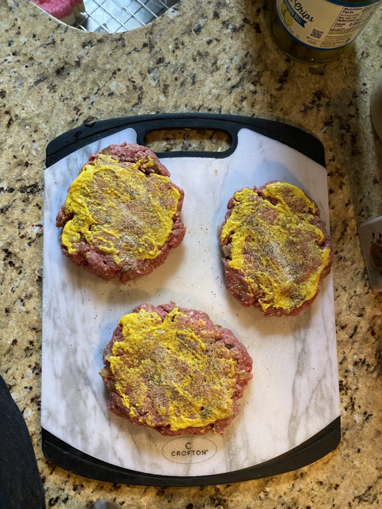 Burger patties with mustard spread on top