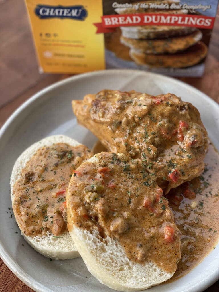 Chicken paprika over bread dumplings in front of a box of bread dumplings