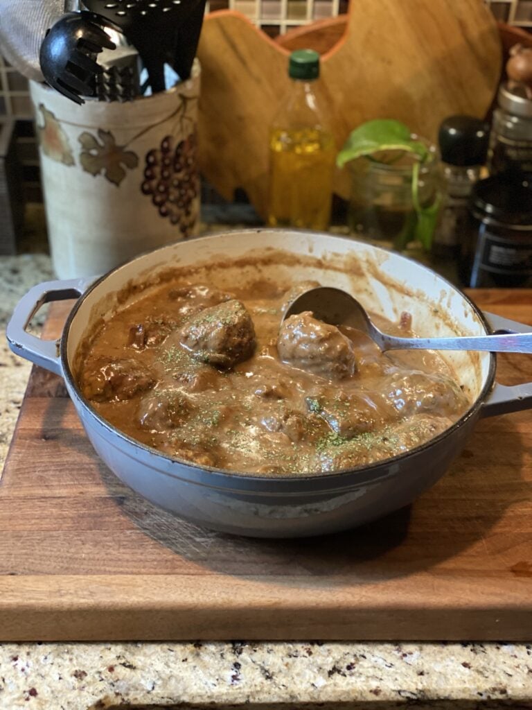 A pot of Salisbury Steak meatballs in creamy mushroom gravy and a ladle