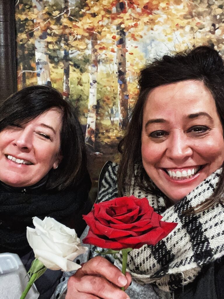 My mom and me holding a white and red rose, respectively