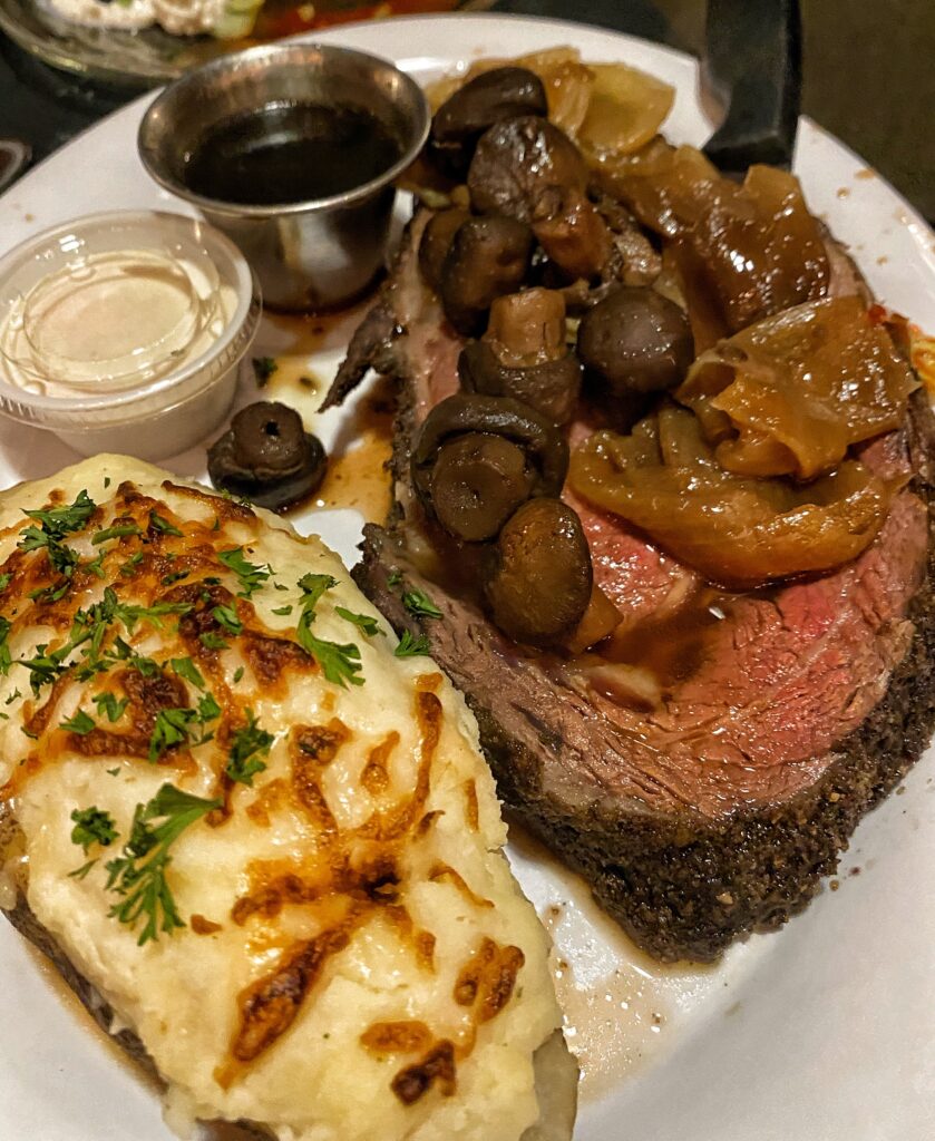 Prime rib with mushrooms and a baked potato