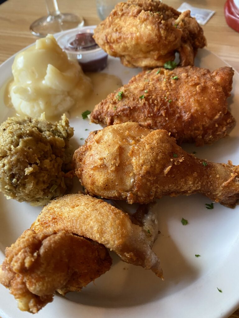 A close up of fried chicken with mashed potatoes and stuffing