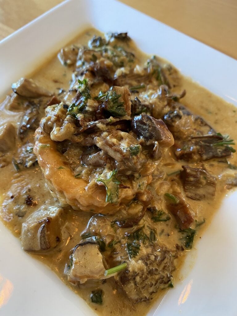 A puff pastry topped with mushrooms in sauce
