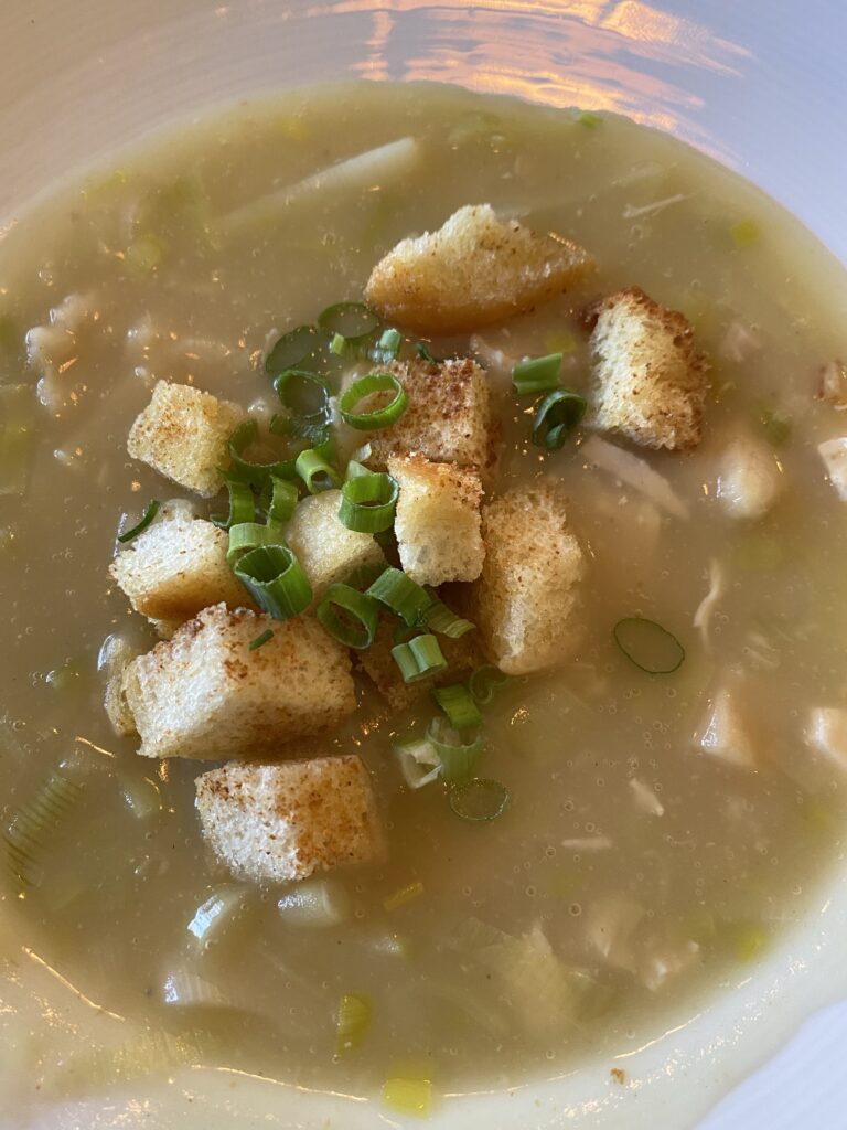 A bowl of creamy leek potato soup with croutons