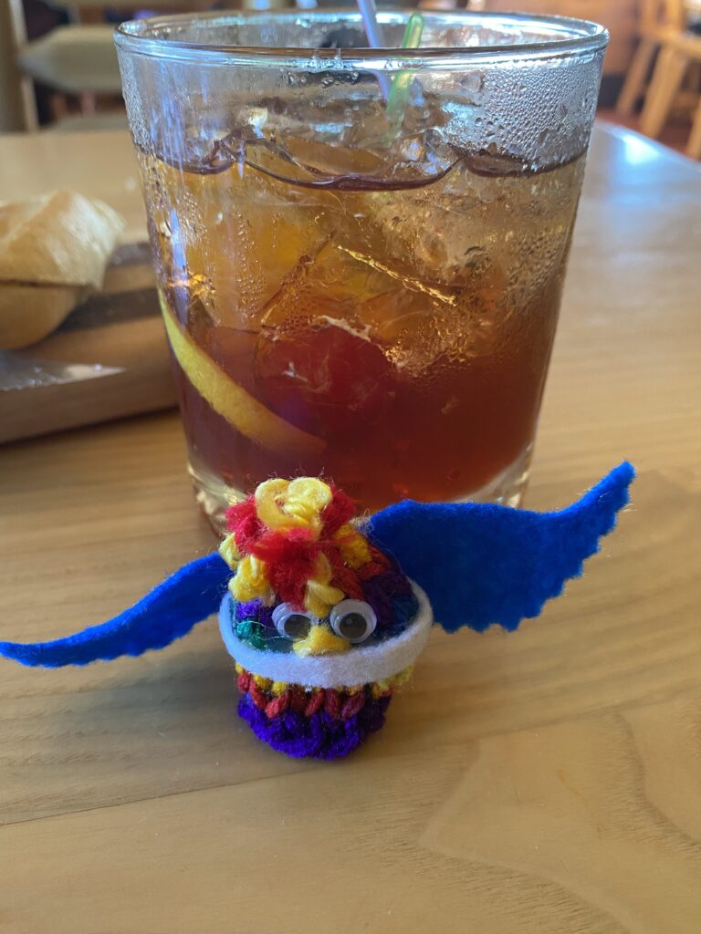 A brandy old fashioned and a small bird finger puppet
