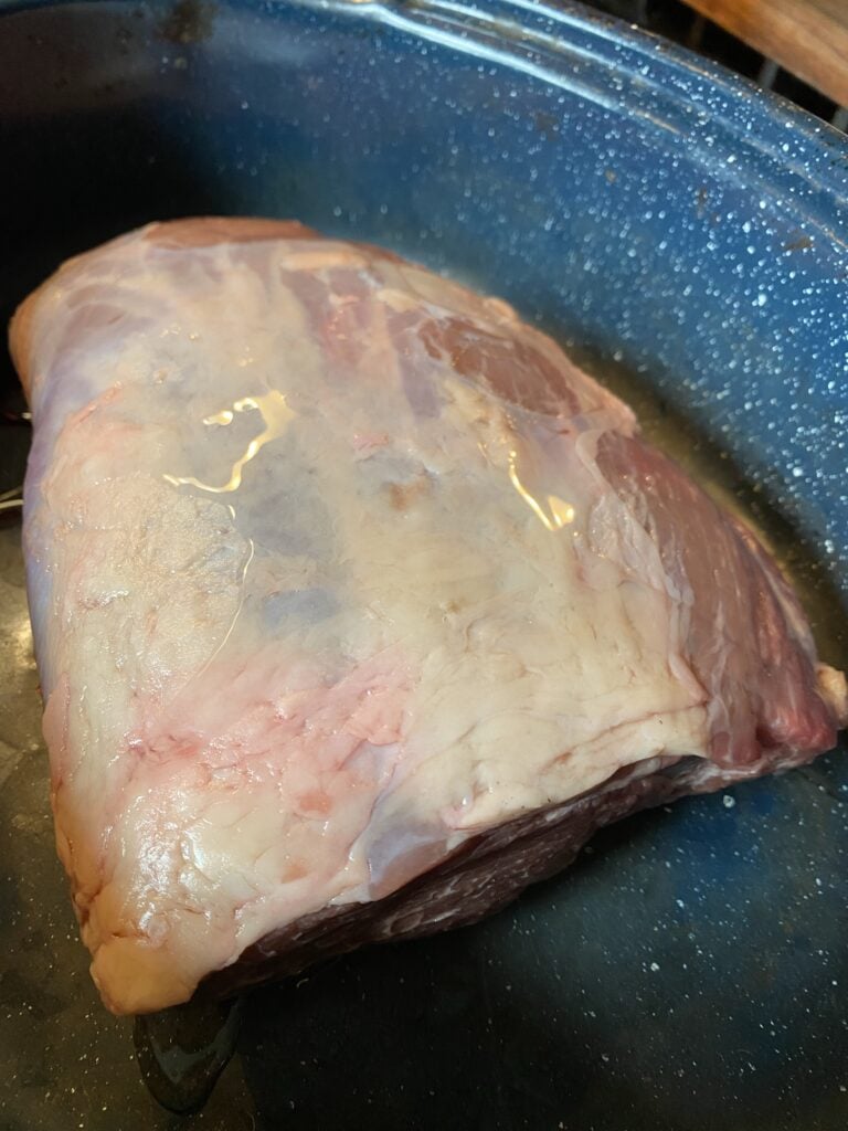 A raw chuck roast in a pot