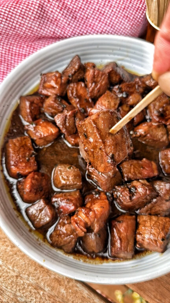 Marinated sirloin steak bites cooked until browned and served as an appetizer.

