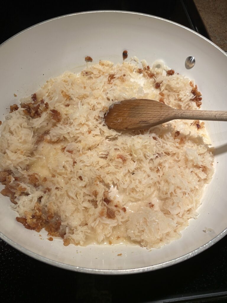 Kraut and bacon bits cooking in a pan