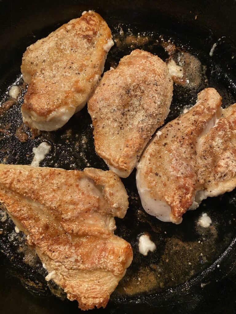 Chicken cooking in a skillet