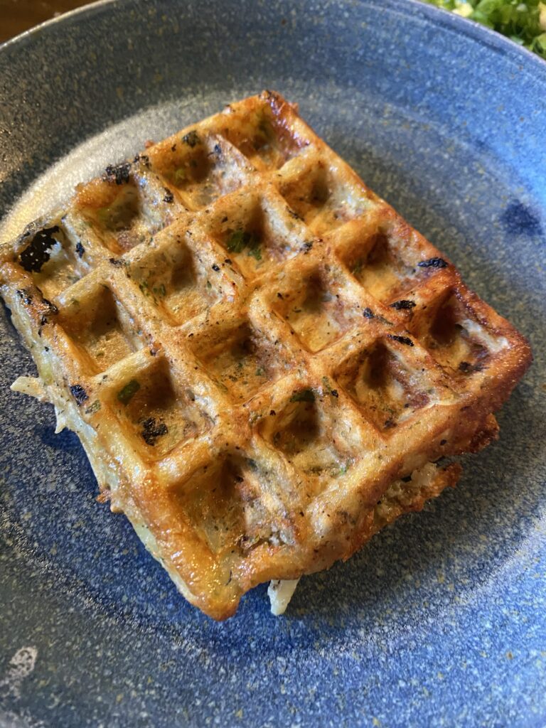 A potato waffle on a blue plate
