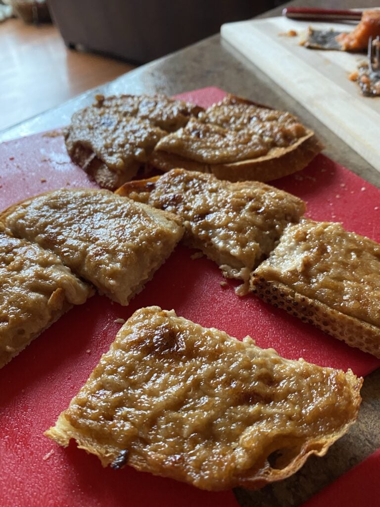 Bite sized chalet appetizer pieces on a red cutting board