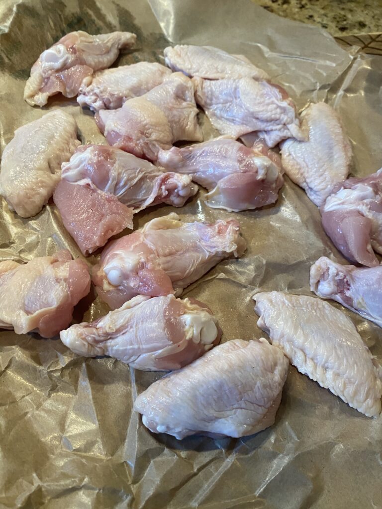 Raw chicken wings on parchment paper