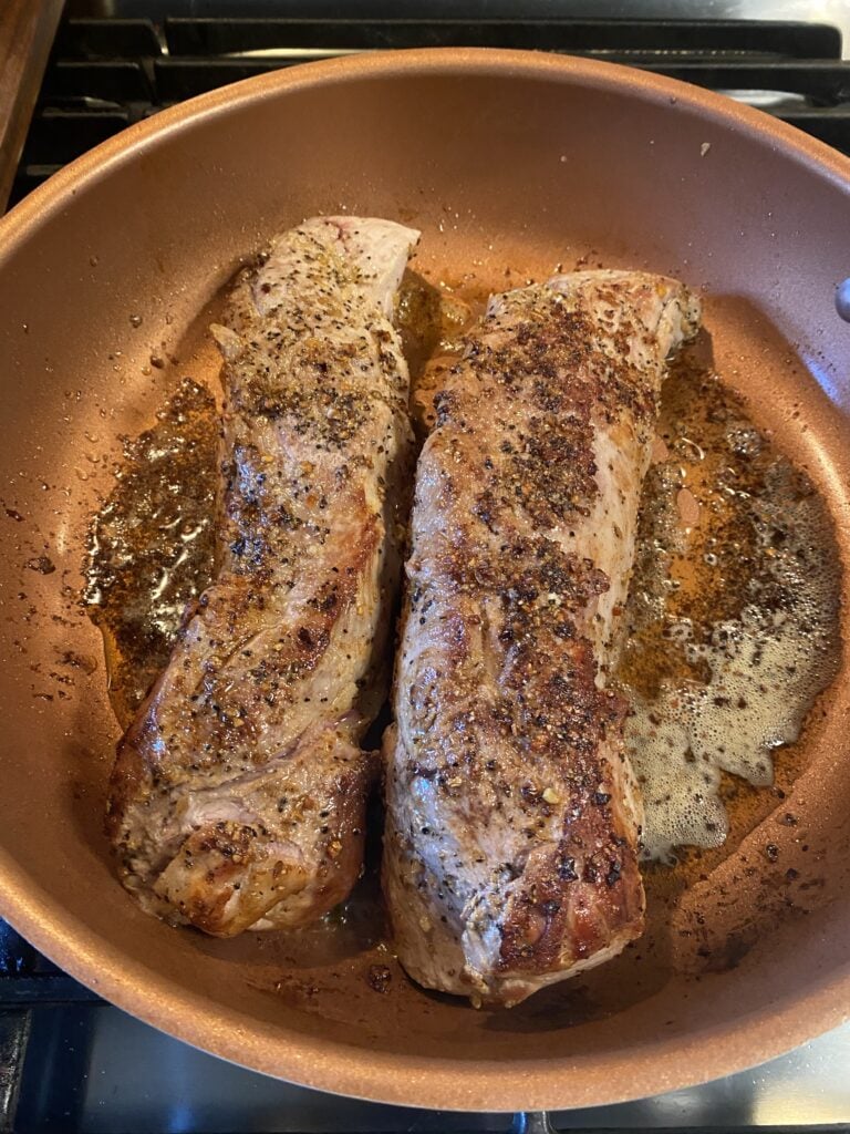 Pork tenderloins cooking in a pan