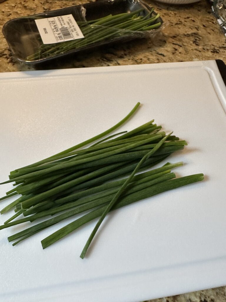 Chives on a white cutting board