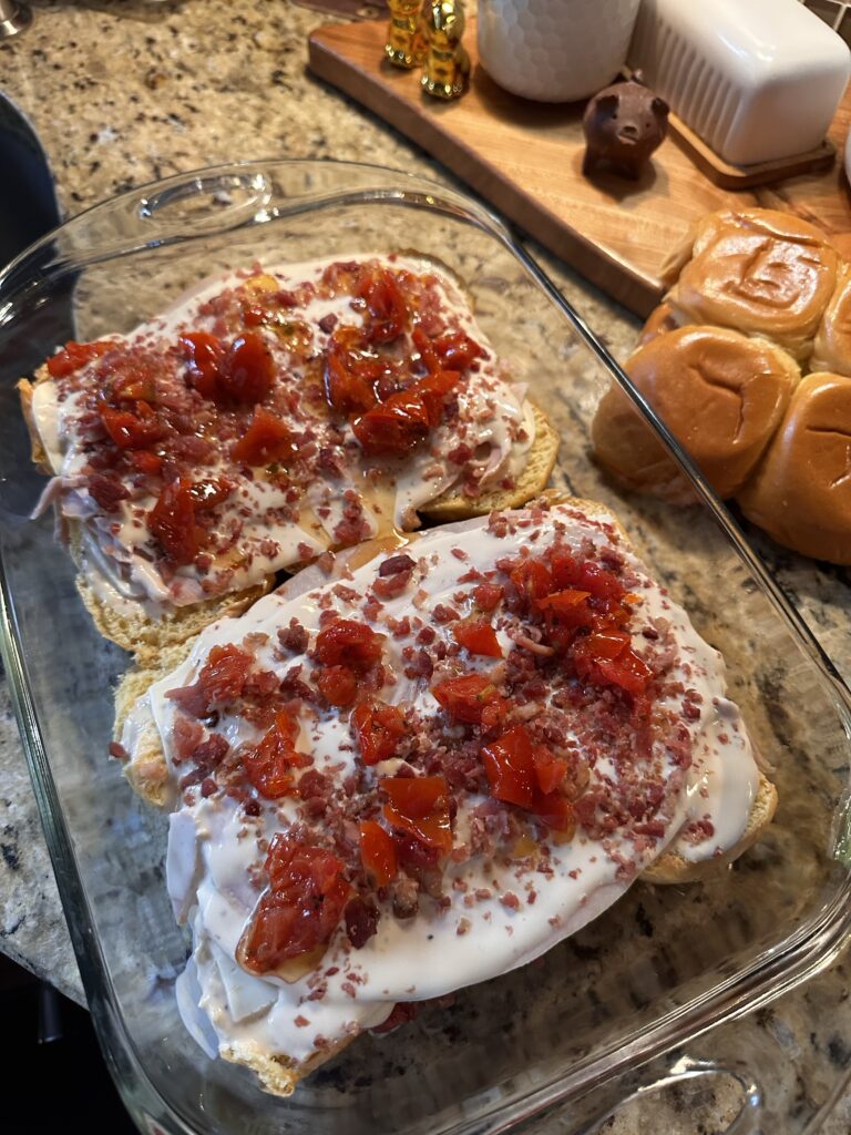 Buns topped with deli turkey, mayo, bacon bits, and sun dried tomatoes