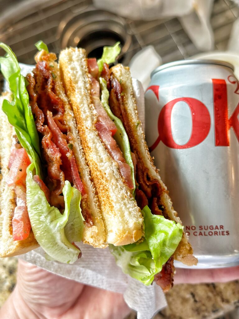 A BLT next to a can of diet Coke