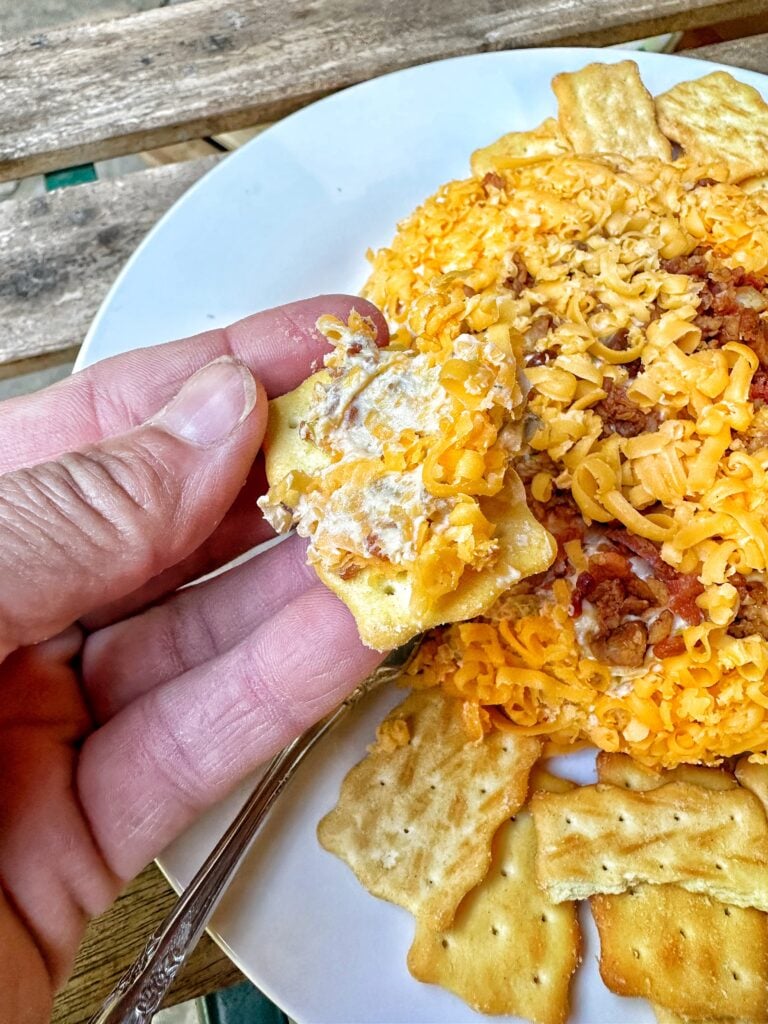 A cracker dipped into the cheeseball