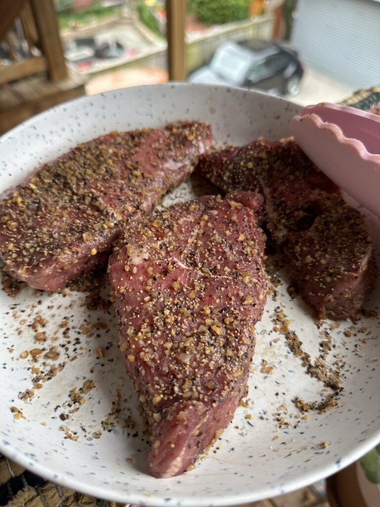 Seasoned sirloins cooking in a pan
