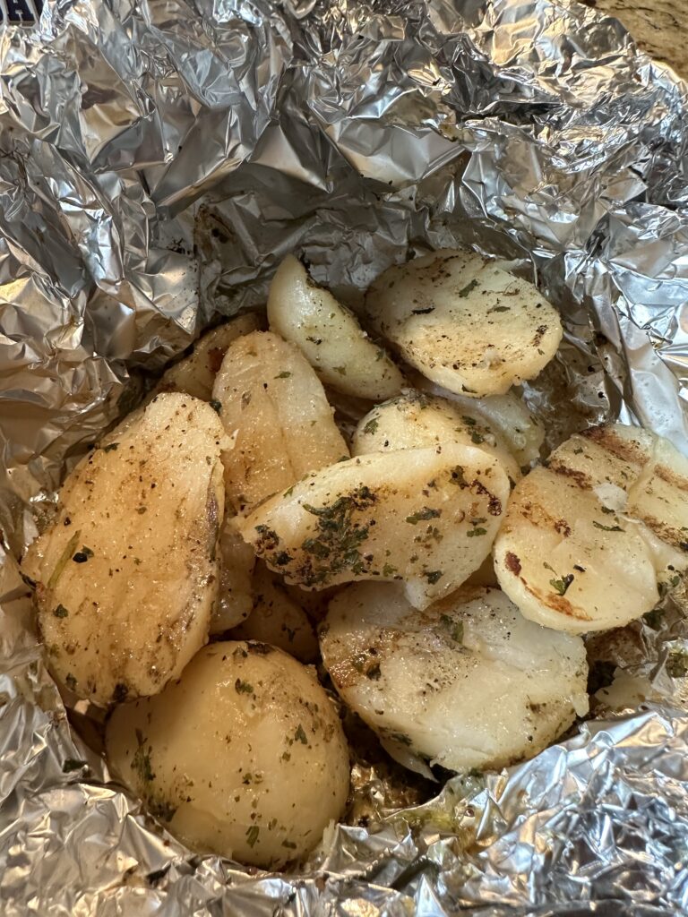 Cooked and seasoned potatoes in foil