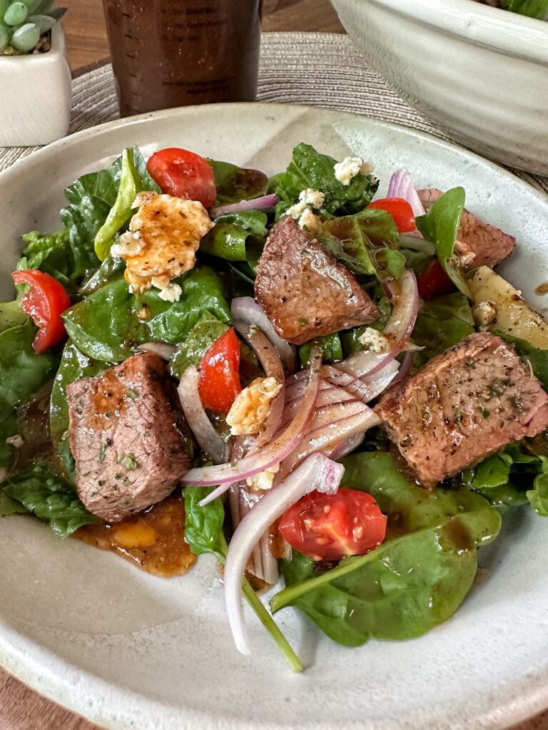 A portion of the finished steak salad on a plate