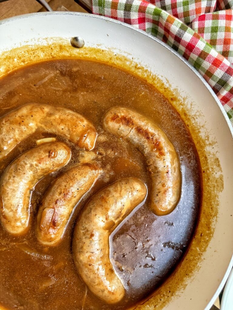 Sausages in onion gravy in a pot