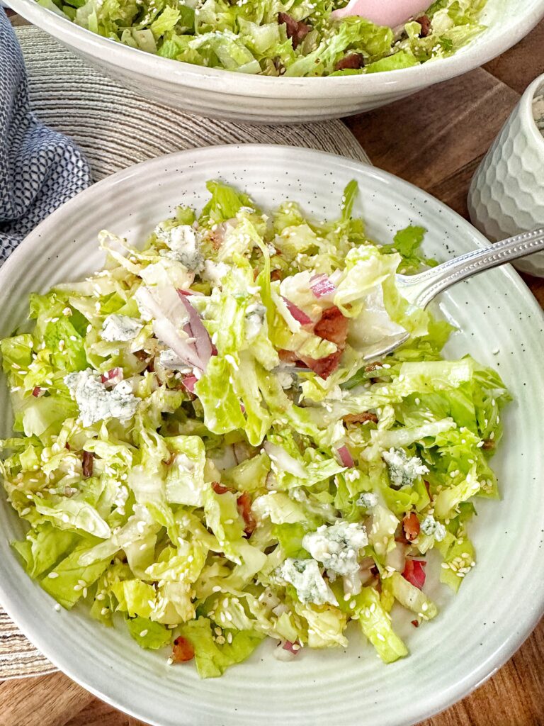 A fork of salad being lifted out of the bow