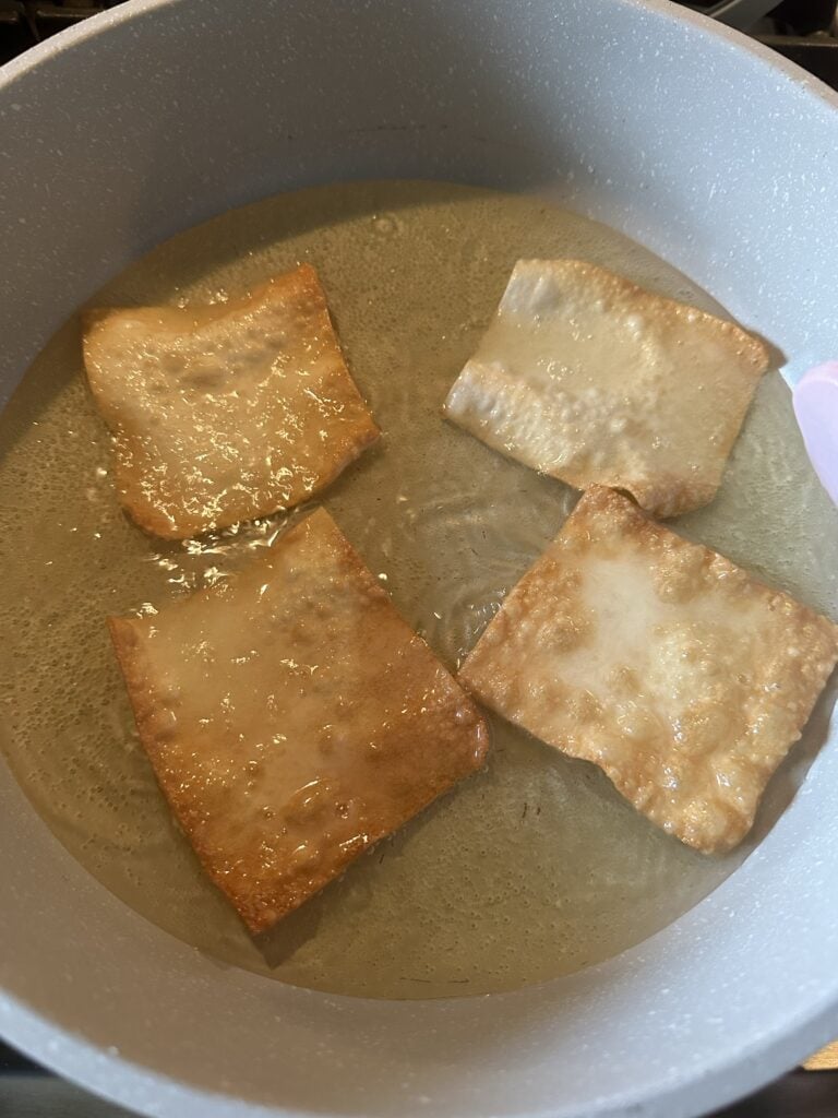 Won ton pieces crisping up in oil in the pan