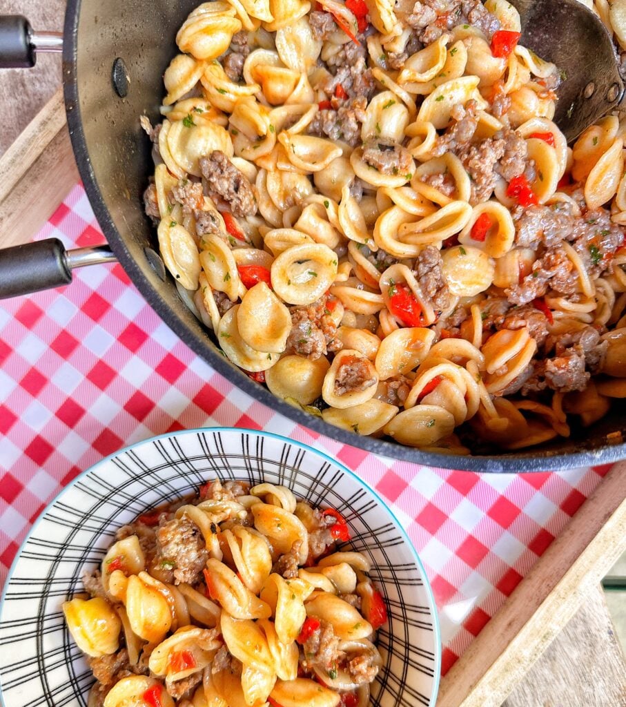 A bowl and pot of Orecchiette Pasta with a Sausage and Roasted Red Pepper Sauce