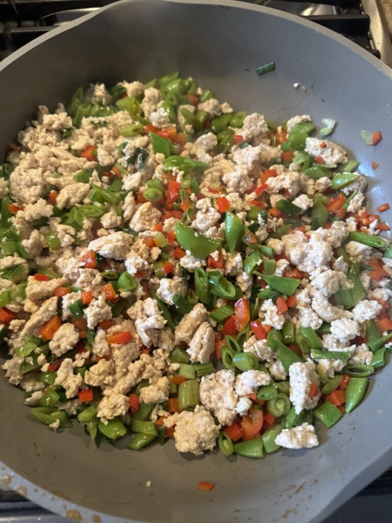 Chicken and veggies cooking up in skillet