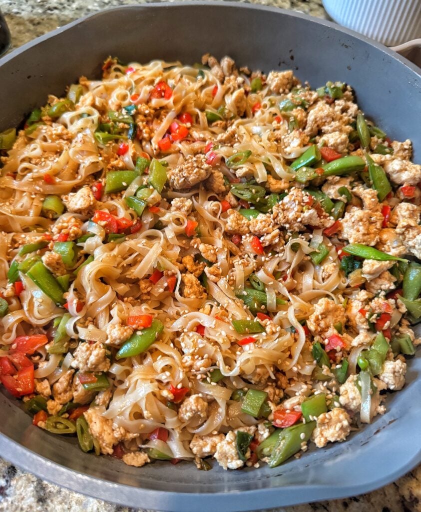 The noodles being finished in a pan