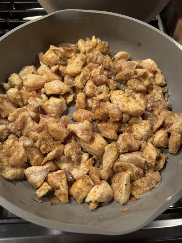Seasoned chicken browning in the pan